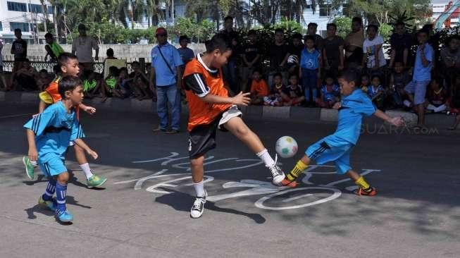 Masyarakat, termasuk anak-anak, mengikuti perayaan HUT Kemerdekaan Republik Indonesia yang ke-70 Tahun di kawasan kolong jembatan layang Lodan, Kampung Bandan, Jakarta, Senin (17/8). [Suara.com/Kurniawan Mas'ud]