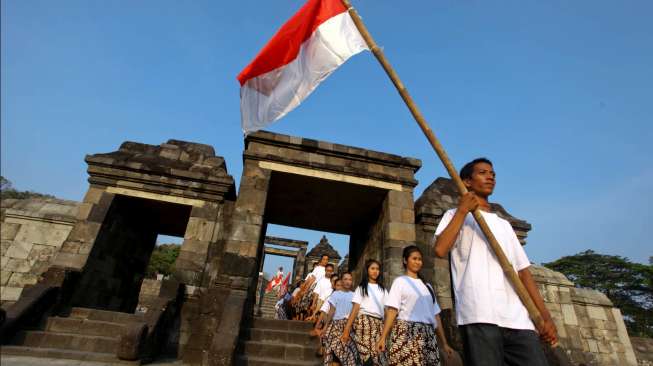 Beberapa peserta mengikuti defile kemerdekaan di kawasan Situs Ratu Boko, Sleman, Yogyakarta, Senin (17/8/2015), turut membawa dan mengibarkan Merah Putih. [Antara/Andreas Fitri Atmoko]