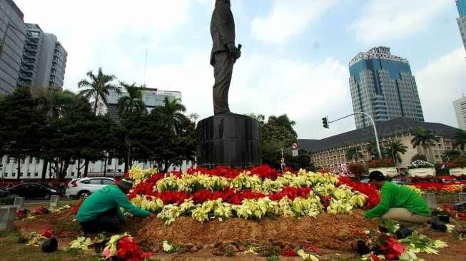 Sejumlah petugas Dinas Pertamanan dan Pemakaman Kota Jakarta Pusat  melakukan perbaikan taman di kawasan silang monas, Jakarta Pusat, Selasa (18/8). [Suara.com/Oke Atmaja]