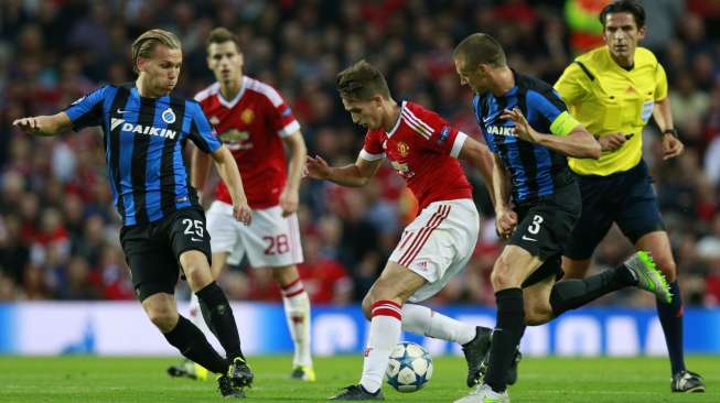 Pemain Brugge mencoba menghentikan laju pemain MU Adnan Januzaj (19/8) [Reuters/Jason Cairduff]