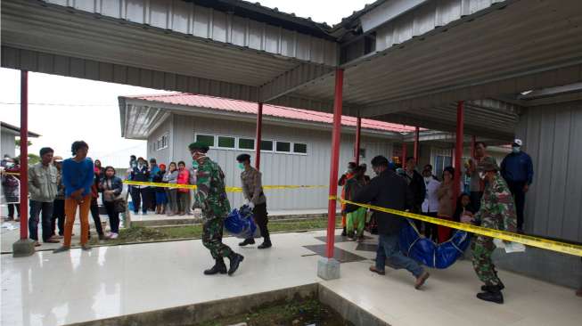 Petugas SAR gabungan menurunkan jenazah korban kecelakaan pesawat Trigana Air dari mobil setibanya di RSUD Oksibil, Kabupaten Pegunungan Bintang, Papua, Rabu (19/8/2015). [Antara/Andika Wahyu]