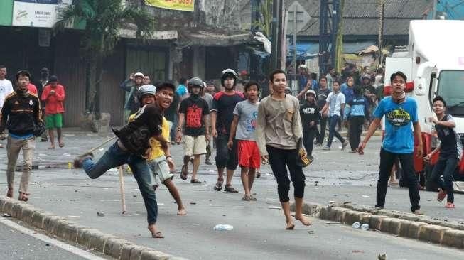 Warga Kampung Pulo, Jatinegara, Jakarta Timur, bentrok dengan Satpol PP dan personel kepolisian, hari Kamis (20/8). [Suara.com/Oke Atmaja]