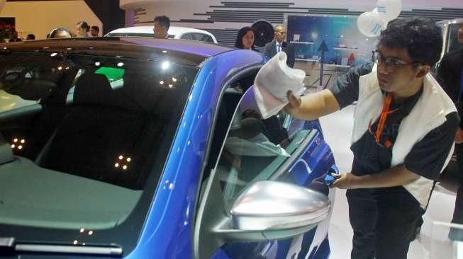 Petugas membersihkan mobil-mobil yang terpajang di ajang pameran Gaikindo International Indonesia Auto Show (GIIAS) 2015 di ICE Serpong, Tangerang, Banten, Kamis (20/8/2015). [Suara.com/Kurniawan Mas'ud]