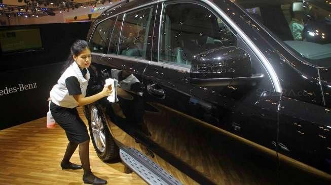 Petugas membersihkan mobil-mobil yang terpajang di ajang pameran Gaikindo International Indonesia Auto Show (GIIAS) 2015 di ICE Serpong, Tangerang, Banten, Kamis (20/8/2015). [Suara.com/Kurniawan Mas'ud]