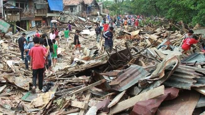 Sejumlah warga Kampung Pulo mencari harta bendanya yang tersisa, di puing-puing bangunan rumahnya yang dibongkar aparat di Jakarta, Kamis (20/8/2015). [Suara.com/Oke Atmaja]