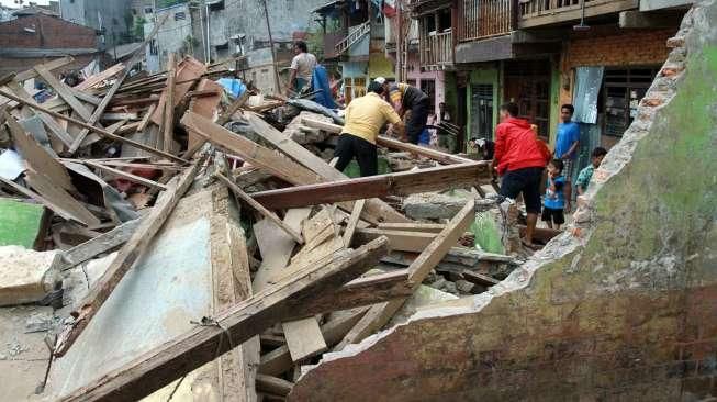 Sejumlah warga Kampung Pulo mencari harta bendanya yang tersisa, di puing-puing bangunan rumahnya yang dibongkar aparat di Jakarta, Kamis (20/8/2015). [Suara.com/Oke Atmaja]