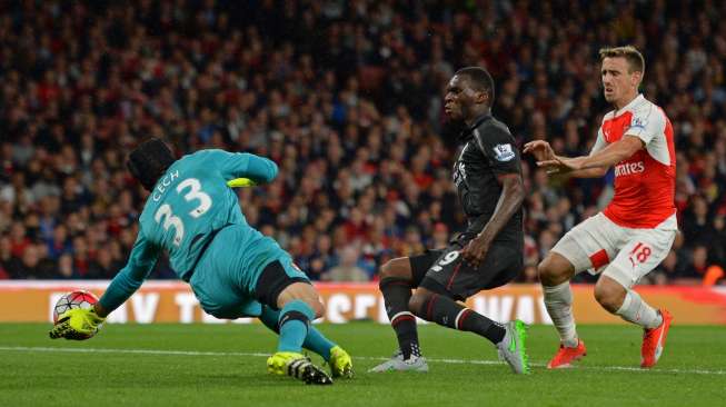 Kiper Arsenal, Petr Cech, menggagalkan peluang striker Liverpool, Christian Benteke di laga Liga Primer, Senin (24/8) [Reuters/Tony O'Brien].