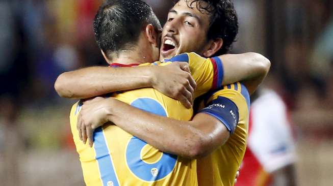 Kapten Valencia, Daniel Parejo (kanan) memeluk rekan setimnya, Javier Fuego setelah mengalahkan Monaco di leg kedua playoff Liga Champions, Selasa (25/8) [Reuters/Eric Gaillard].