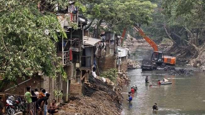 Petugas dibantu TNI melakukan pengerukan Sungai Ciliwung di kawasan kampung Pulo-Bukit Duri, Jakarta, Minggu (6/9).[Suara.com/Kurniawan Mas'ud]