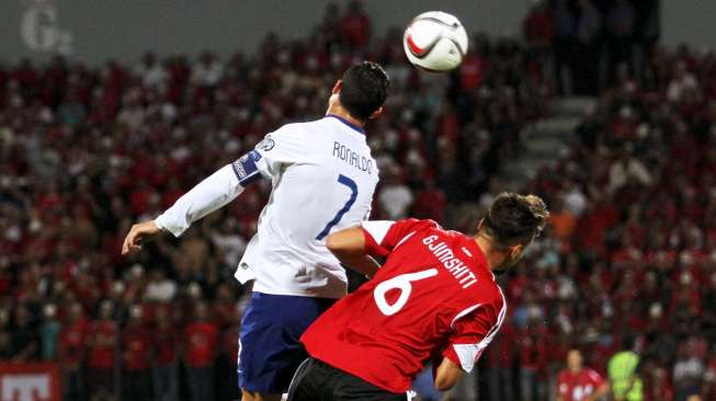 Pemain Albania Berat Djimsiti (R) berebut bola di udara dengan kapten Portugal Cristiano Ronaldo. Reuters/Arben Celi