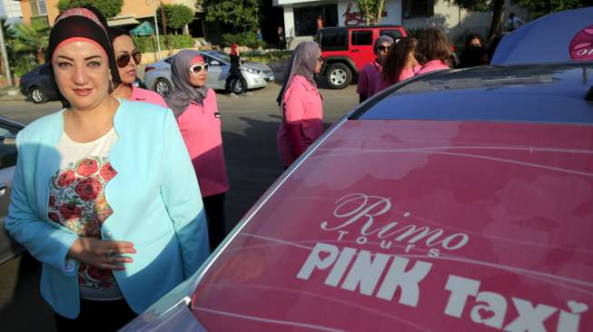 Reem Fawzy (kiri), direktur perusahaan Pink Taxi, berdiri di parkiran bersama armada dan para perempuan sopir perusahaannya, di Kairo, Mesir, Minggu (6/9/2015). [Reuters/Amr Abdallah Dalsh]