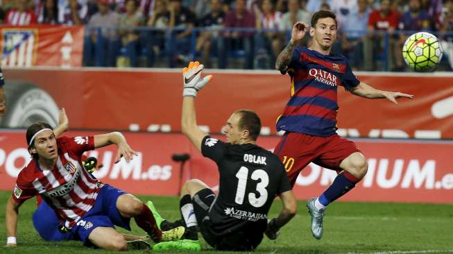 Pemain Barcelona Lionel Messi (R) mencetak gol ke gawang Atletico Madrid. Reuters/Javier Barbancho