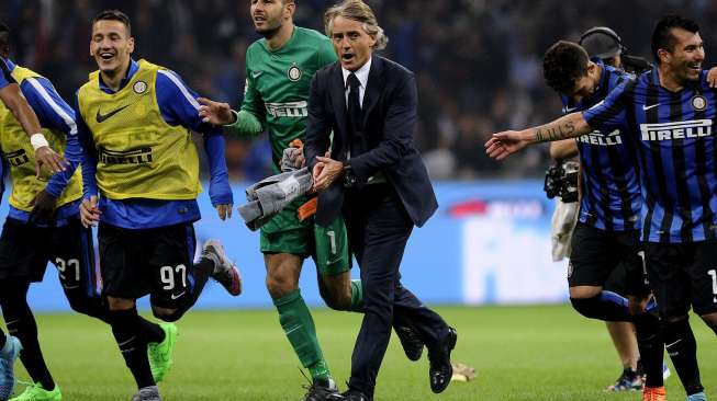 Pemain Inter Milan beserta pelatihnya merayakan kemenangan mereka dengan skor 1-0 atas AC Milan dalam laga big match Serie A, Derby Della Madonnina, di Stadion San Siro, Milan, Minggu (13/9/2015). [Reuters/Giorgio Perottino]