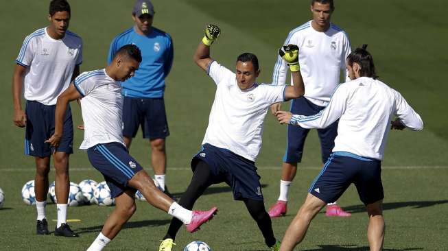 Kiper Real Madrid Keylor Navas (tengah) mengontrol bola diantara Casemiro dan Gareth Bale. Reuters/Andrea Comas