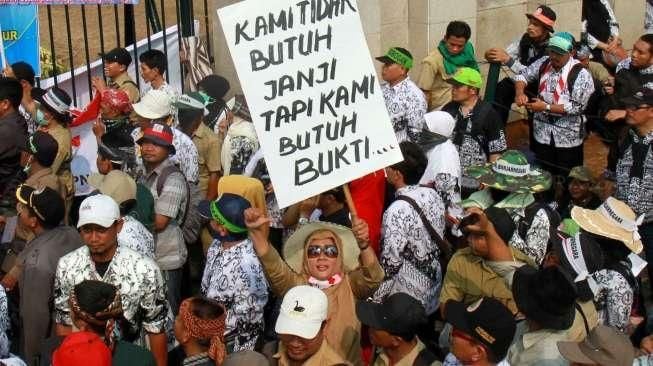 Ribuan guru honorer yang tergabung dalam Persatuan Guru Republik Indonesia (PGRI) menggelar aksi mogok dan unjuk rasa di depan gedung DPR/MPR, Jakarta, Selasa (15/9).