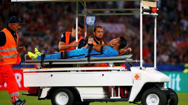 Pemain Barcelona, Rafinha, saat dibawa keluar lapangan karena cedera lantaran diganjal keras Radja Nainggolan dari AS Roma, dalam laga Liga Champions di Stadion Olimpico, Italia, Rabu (16/9/2015). [Reuters/Tony Gentile]