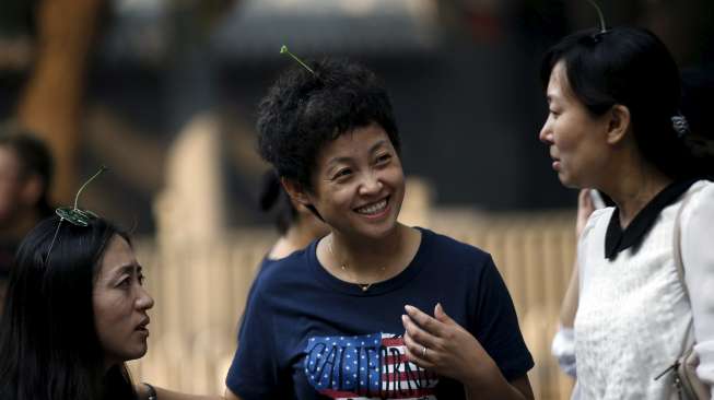 Warga Beijing, baik tua maupun muda mengenakan hiasan rambut berbentuk bunga dan tunas tanaman di jalan Nanluoguxiang, Beijing. [Reuters/Kim Kyung-Hoon]