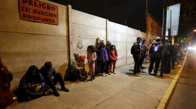 Warga Santiago memilih berada di luar rumah mereka pasca-gempa yang melanda wilayah Chile, Kamis (17/9). [Reuters/Carlos Vera]