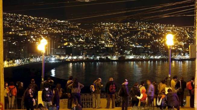 Warga melihat laut dari bukit Cerro Baron di Kota Valparaiso pasca-gempa berkekuatan 8,3 SR yang melanda wilayah Chile, Kamis (17/9).[Reuters/Rodrigo Garrido]