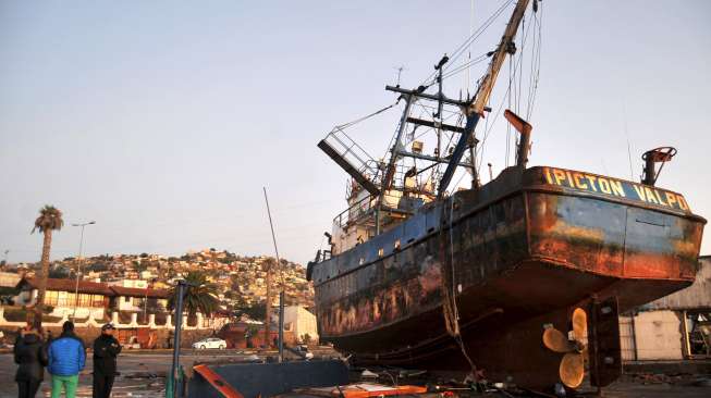 Kapal-kapal yang terbawa gelombang tsunami terdampar di jalanan Kota Coquimbo, sebelah utara Santiago, Chile, usai gempa berkekuatan 8,3 Skala Richter mengguncang negeri tersebut, hari Kamis (17/9). [Reuters/Ivan Alvarado]