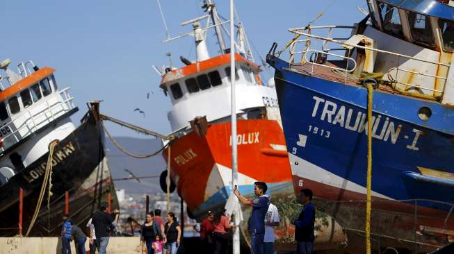 Kapal-kapal yang terbawa gelombang tsunami terdampar di jalanan Kota Coquimbo, sebelah utara Santiago, Chile, usai gempa berkekuatan 8,3 Skala Richter mengguncang negeri tersebut, hari Kamis (17/9). [Reuters/Ivan Alvarado]