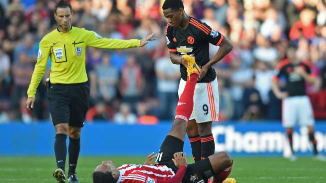 Pemain Manchester United Anthony Martial membantu pemain Southampton Virgil van Dijk setelah yang mengalami cedera. [Reuters/Tony O'Brien Livepic]