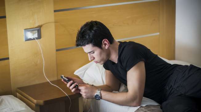 Ilustrasi mengisi ulang baterai ponsel sebelum tidur (Shutterstock).