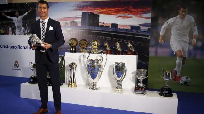 Bintang Real Madrid Cristiano Ronaldo berpose dengan trofinya. Reuters/Sergio Perez