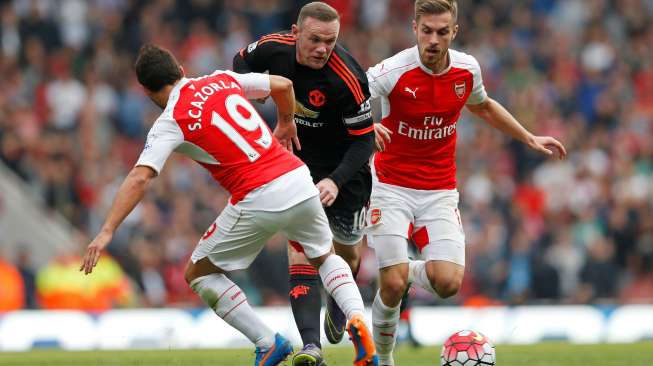 Striker Manchester United Wayne Rooney ditempel dua pemain Arsenal Aaron Ramsey dan Santi Cazorla. Reuters / Carl Recine Livepic