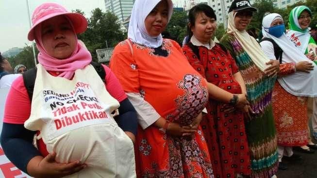 Para aktivis dari Komite Perempuan Industrial Indonesian Council melakukan aksi di depan Istana Negara, Jakarta, Rabu (7/10/2015). [Suara.com/Oke Atmaja]