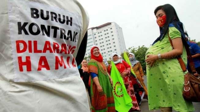 Para aktivis dari Komite Perempuan Industrial Indonesian Council melakukan aksi di depan Istana Negara, Jakarta, Rabu (7/10/2015). [Suara.com/Oke Atmaja]