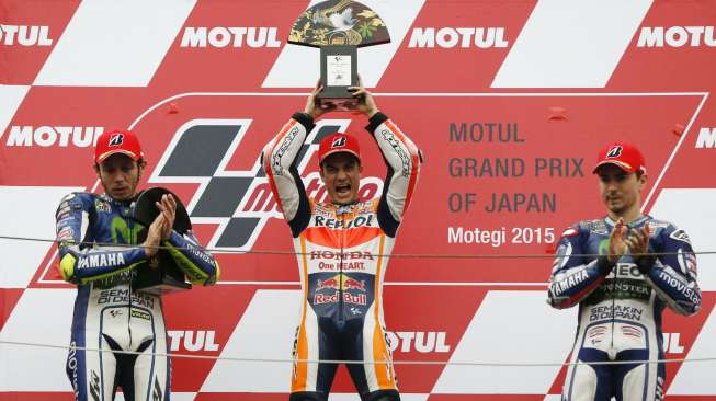 Pebalap MotoGP Honda Dani Pedrosa (tengah) mengangkat trofi kemenangannya di Jepang dan juga ke-50 di grand prix. Reuters/Issei Kato