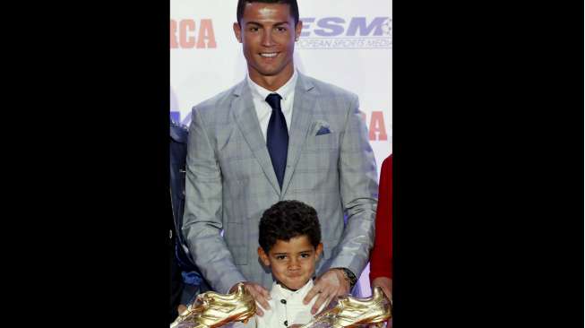 Bintang Real Madrid Cristiano Ronaldo berpose dengan anaknya, Cristiano Ronaldo Jr bersama trofi Sepatu Emasnya. Reuters/Andrea Comas