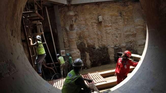 Petugas memeriksa lokasi pengeboran sodetan Ciliwung di arriving shaft (titik pertemuan), daerah Jalan Otista III, Jakarta, Rabu (14/10/2015). [Suara.com/Kurniawan Mas'ud]