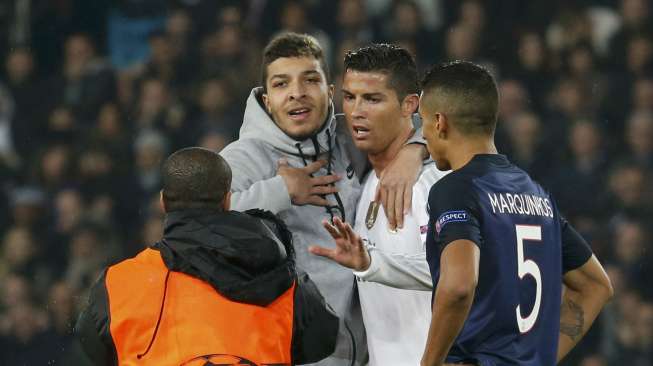 Seorang fans memasuki arena pertandingan dan memeluk Ronaldo saat PSG menjamu Real Madrid (22/10)[Reuters/Charles Platiau]