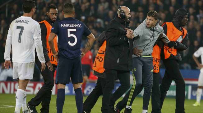 Seorang fans memasuki arena pertandingan dan memeluk Ronaldo saat PSG menjamu Real Madrid (22/10)[Reuters/Charles Platiau]