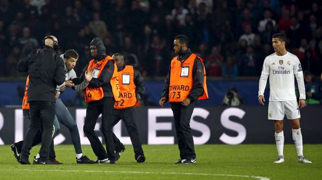 Seorang fans memasuki arena pertandingan dan memeluk Ronaldo saat PSG menjamu Real Madrid (22/10)[Reuters/Charles Platiau]