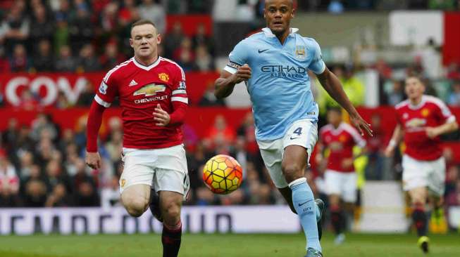 Kapten MU Wayne Rooney (kiri) berebut bola dengan kapten City Vincent Kompany (25/10) [Reuters/Eddie Keogh]