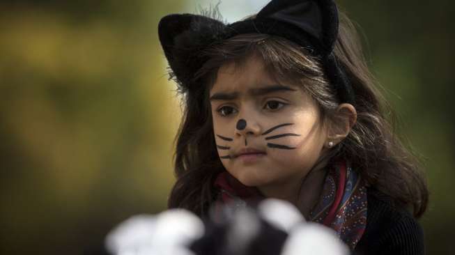 Seorang bocah mengenakan kostum kucing dalam Parade Halloween Anak di Washington. [Reuters/Carlo Allegri]