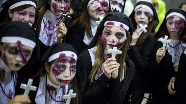 Sejumlah perempuan mengenakan kostum biarawati bertampang seram dalam perayaan Halloween di Shibuya, Jepang. [Reuters/Thomas Peter]