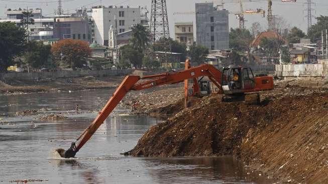 Pekerja dengan menggunakan ekskavator melakukan pengerukan lumpur di Kanal Banjir Barat (KBT) di kawasan Tanah Abang, Jakarta, Rabu (4/11/2015). [Suara.com/Kurniawan Mas'ud]