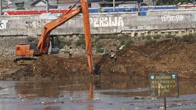 Pekerja dengan menggunakan ekskavator melakukan pengerukan lumpur di Kanal Banjir Barat (KBT) di kawasan Tanah Abang, Jakarta, Rabu (4/11/2015). [Suara.com/Kurniawan Mas'ud]