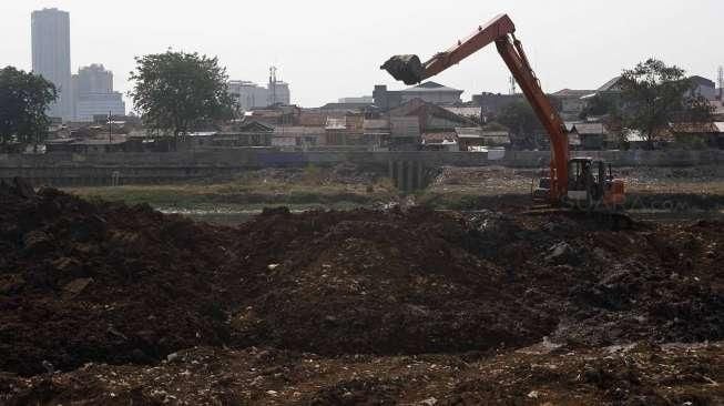 Pekerja dengan menggunakan ekskavator melakukan pengerukan lumpur di Kanal Banjir Barat (KBT) di kawasan Tanah Abang, Jakarta, Rabu (4/11/2015). [Suara.com/Kurniawan Mas'ud]