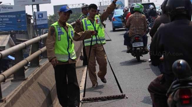 Komunitas Sapu Bersih (Saber) bersama Satuan Polisi Lalu Lintas (Satlantas) Jakarta Barat melakukan operasi ranjau paku di Jalan Kyai Tapa, Grogol, Jakarta, Jumat (6/11).