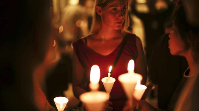 Warga Prancis di Thailand bersama rekan-rekannya berkumpul sambil membawa lilin, terkait insiden Paris, di lokasi Alliance Francaise di Bangkok, Sabtu (14/11/2015). [Reuters/Athit Perawongmetha]