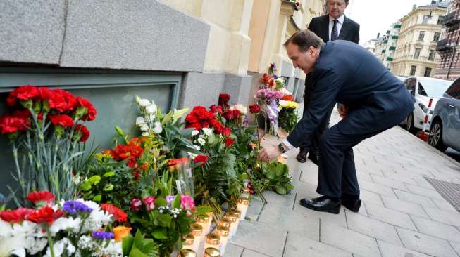 Perdana Menteri Swedia, Stefan Lofven, meletakkan setangkai mawar merah di luar Kedubes Prancis di Stockholm, Sabtu (14/11/2015), terkait insiden serangan Paris. [Reuters/Johan Nilsson]