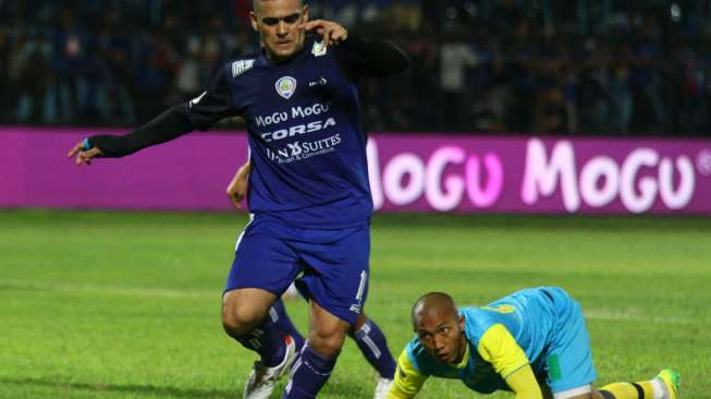 Pemain Arema Cronus, Cristian Gonzales (kiri) melewati kiper tim Persipasi Bandung Raya (PBR), Aditya Harlan (kanan). Antara Foto/Ari Bowo Sucipto