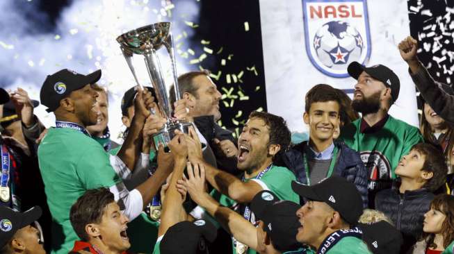 Pemain New York Cosmos Raul (tengah) merayakan trofi juara NASL dengan rekan setimya. Reuters/Brendan McDermid.