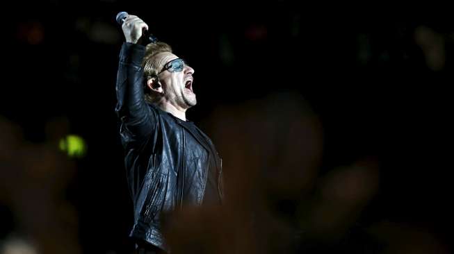 Aksi vokalis band Irlandia U2 Bono saat menggelar konser di Accorhotels Arena di Paris, Prancis, Minggu (16/12). [Reuters/Benoit Tessier]