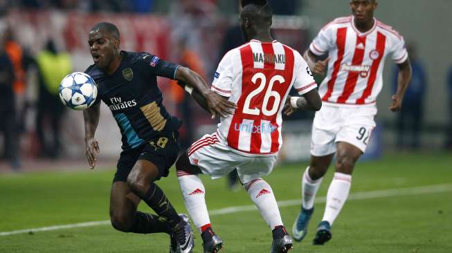 Pemain Arsenal Joel Campbell berebut bola dengan pemain Olympiacos Arthur Masuaku (10/12) [Reuters/Andrew Couldridge]